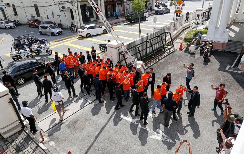 A group of detainees, including 24 Road Transport Department personnel, arrive at the Penang Court Complex in George Town April 17, 2019. u00e2u20acu201d Picture by Sayuti Zainudin