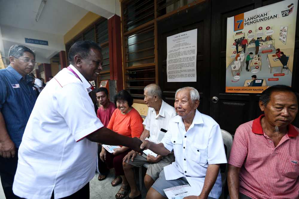 PKR candidate Dr S. Streram greets voters at a polling centre in Rantau April 13,2019. u00e2u20acu2022 Picture by Ahmad Zamzahuri