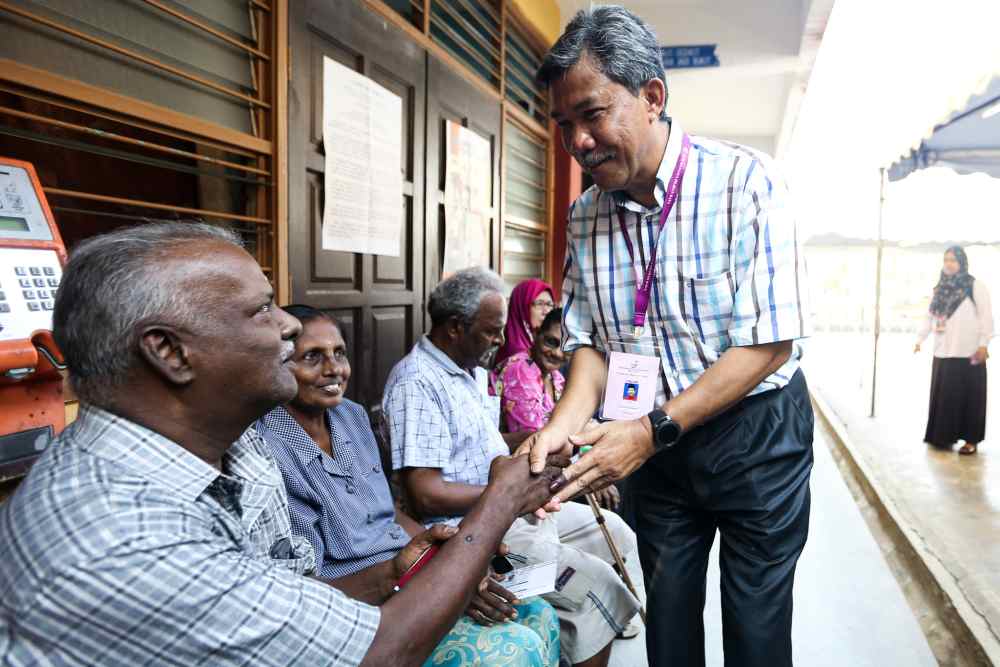 Barisan Nasional candidate Datuk Seri Mohamad Hasan greets voters at a polling centre in Rantau April 13,2019. u00e2u20acu2022 Picture by Ahmad Zamzahuri