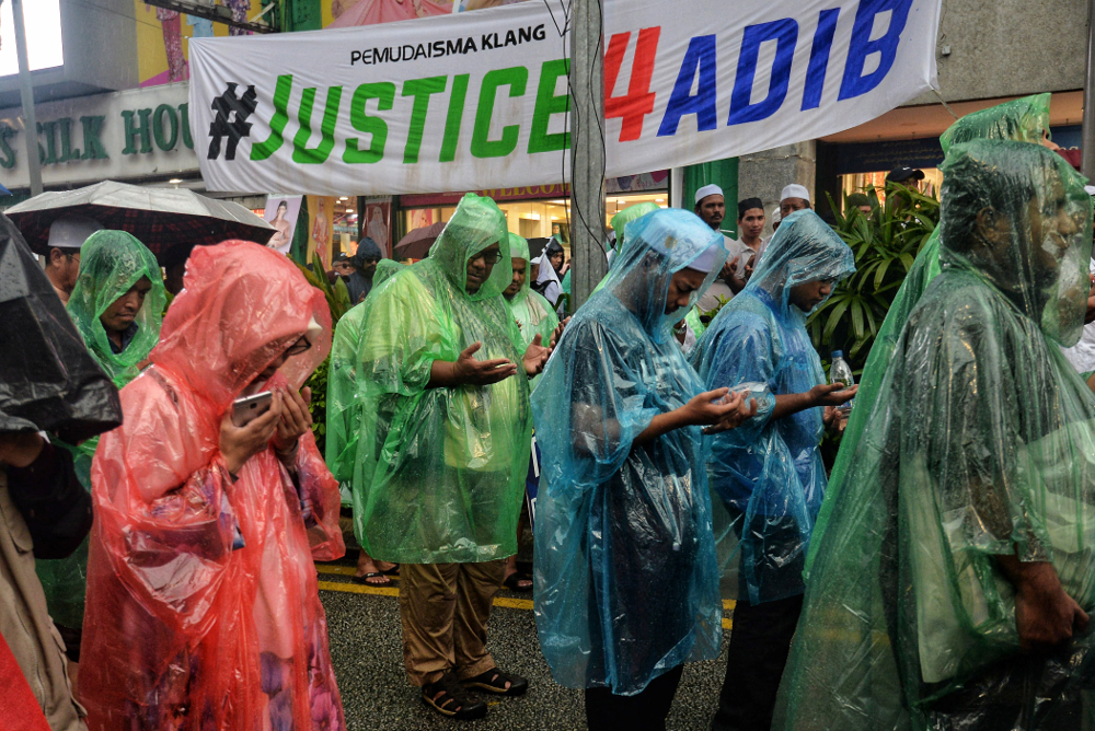 Participants seek shelter from the rain during the Ummah defending Islam rally in Kuala Lumpur May 4, 2019. u00e2u20acu201d Picture by Shafwan Zaidon