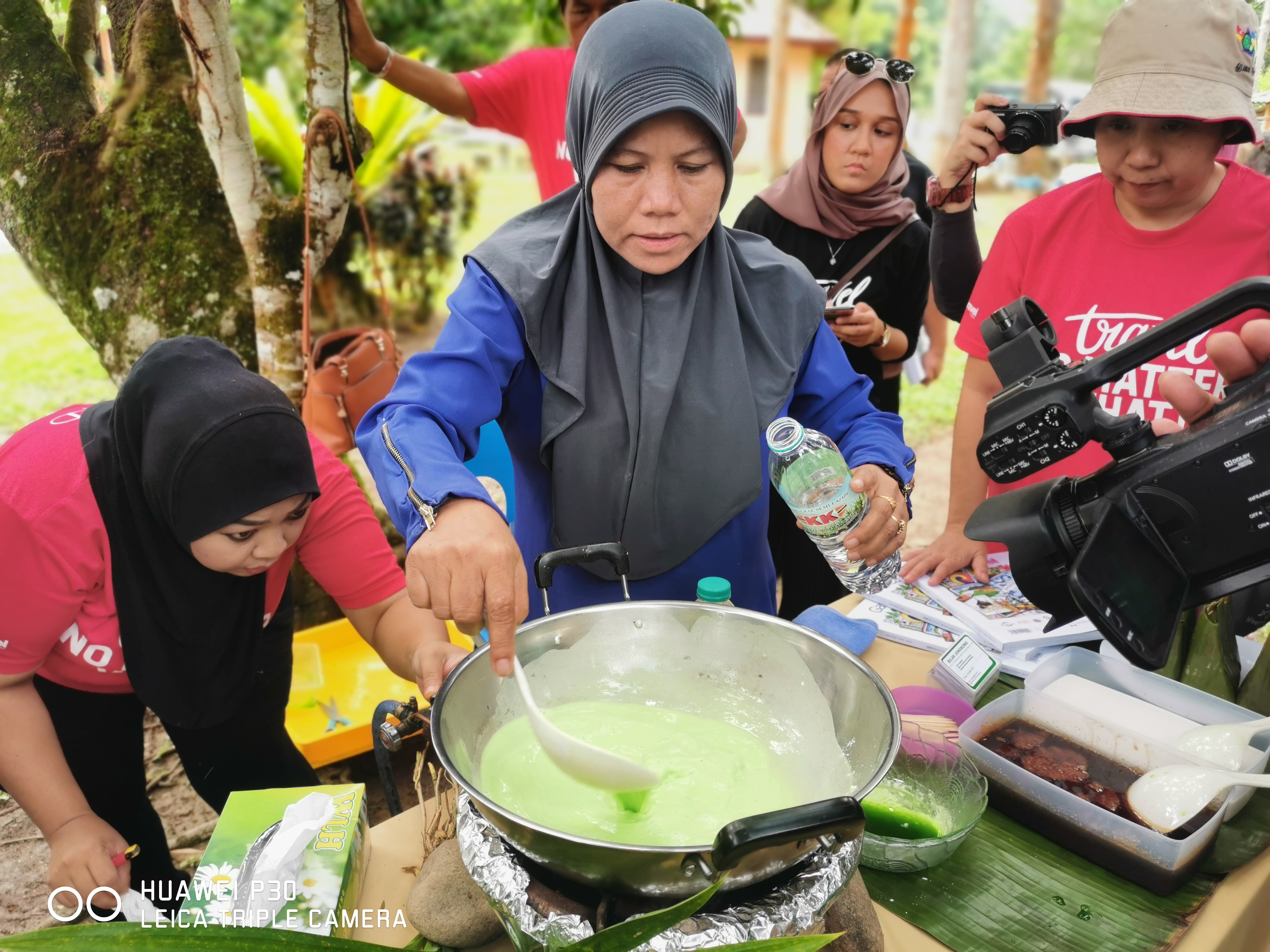 Kak Bulan Jongkong示范将淋上斑斓汁和水的粘米粉炒成糕。-杨琇媖摄-