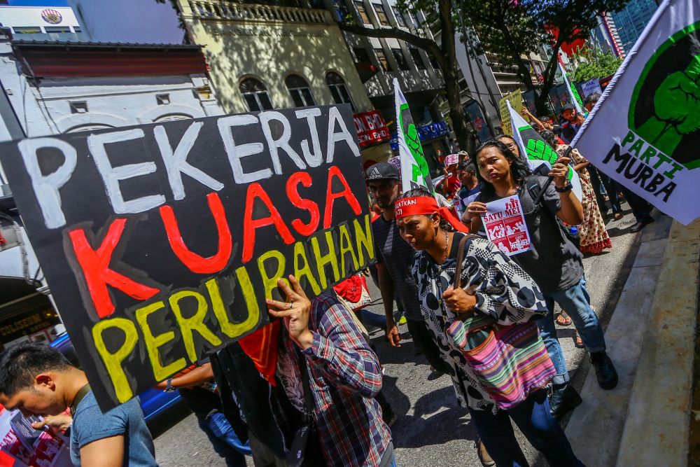 People hold aloft placards and banners as they march from the Maju Junction Mall to Dataran Merdeka during a rally held in conjunction with Labour Day in Kuala Lumpur May 1, 2019. u00e2u20acu201d Picture by Hari Anggara