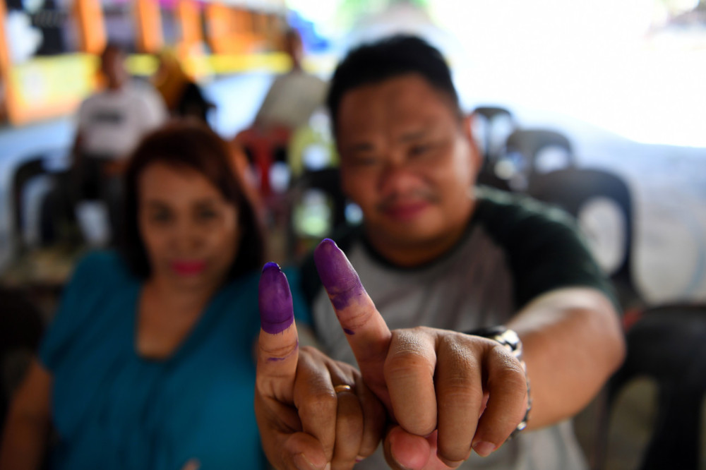 Tan Hat Tiong, 50, and his wife Ainawait Saari, 66, show their fingers after casting their votes in todayu00e2u20acu2122s by-election in Sandakan at Sekolah Kebangsaan Tanjung Papat 1 and 2 May 11, 2019. u00e2u20acu201d Bernama pic 