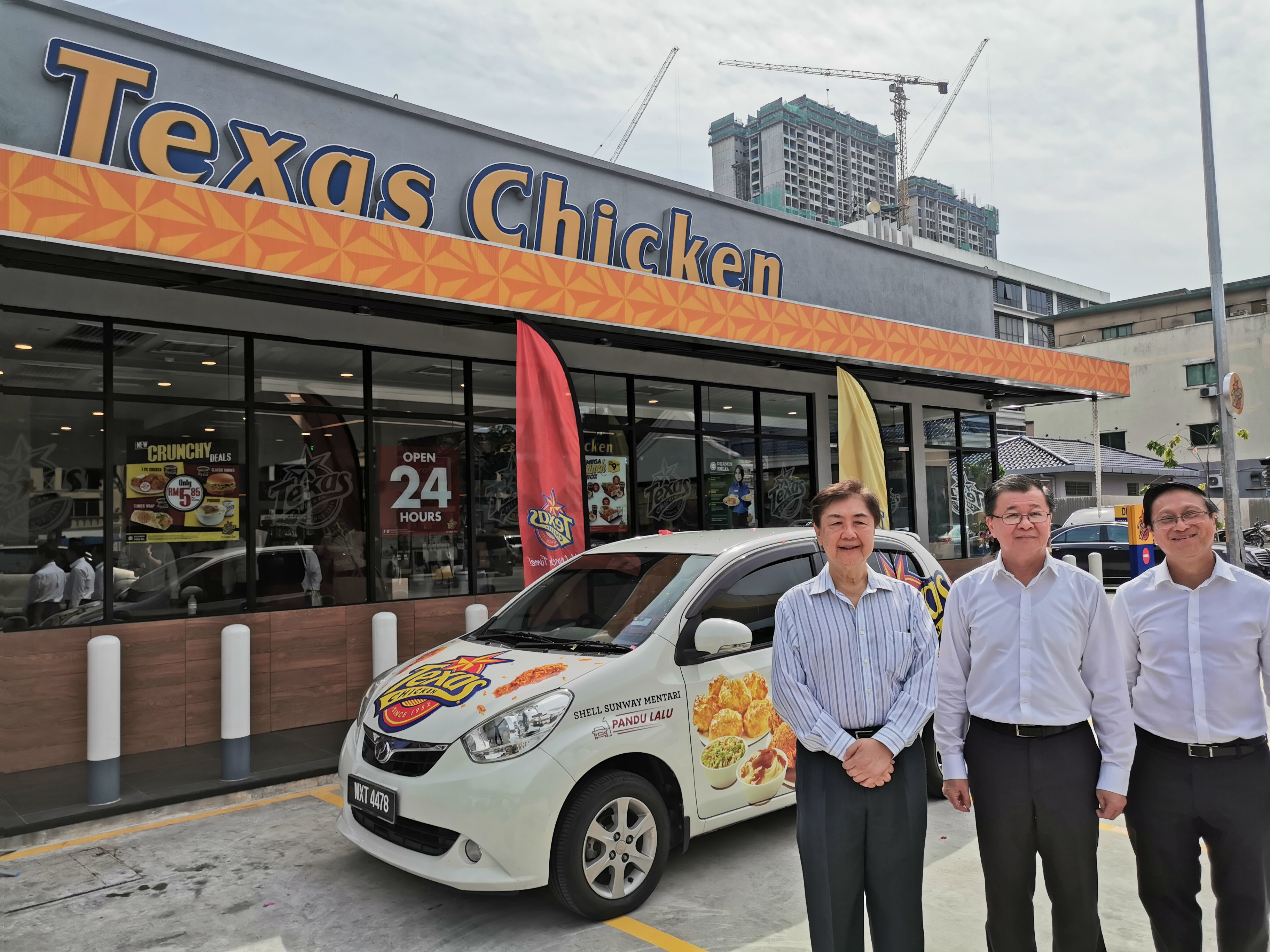 左起拿督陈友文、许星国和林德发在新开张的Texas Chicken Drive-Thru分行前合影。-杨琇媖摄-