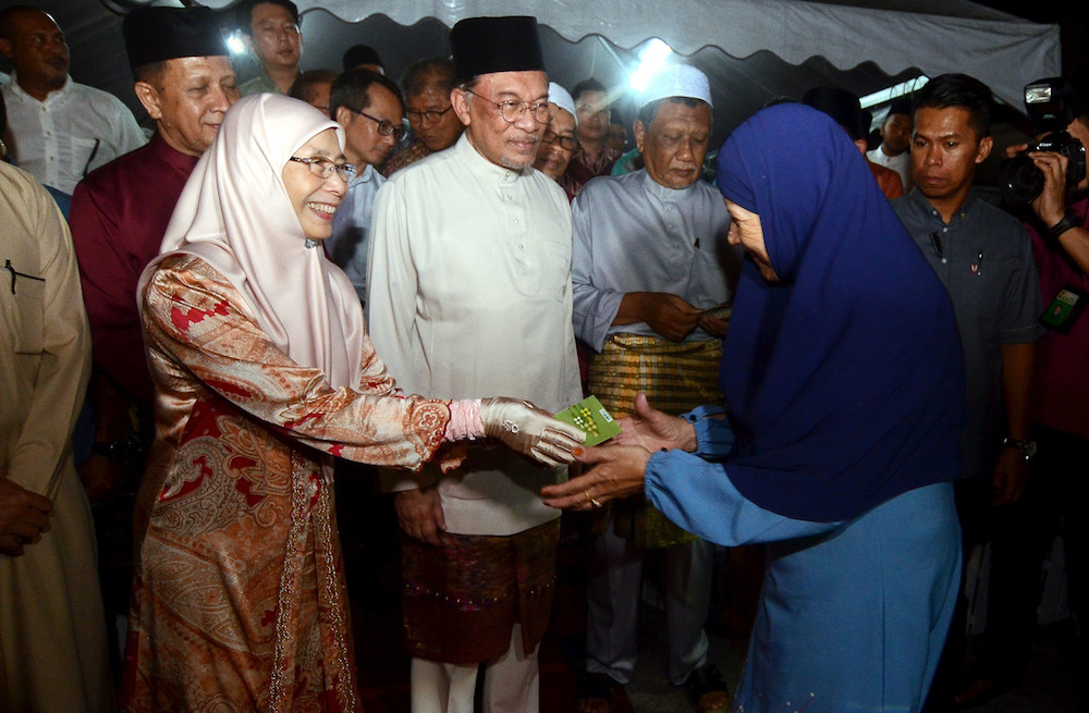 Datuk Seri Dr Wan Azizah Wan Ismail distributes duit raya as Datuk Seri Anwar Ibrahim looks on at a dinner at Kubang Semang Mosque in Bukit Mertajam June 6, 2019. u00e2u20acu201d Bernama pic