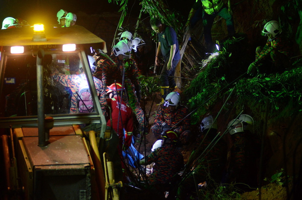 Fire and Rescue Department personnel search for victims of a landslide in Tanjung Bungah, George Town June 25, 2019. u00e2u20acu201d Bernama pic