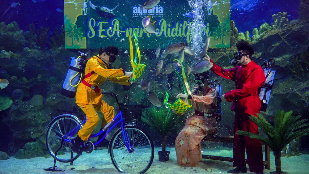 Ketupat在水中飘扬，潜水员一面表演一面喂食鱼儿。-Aquaria KLCC提供-