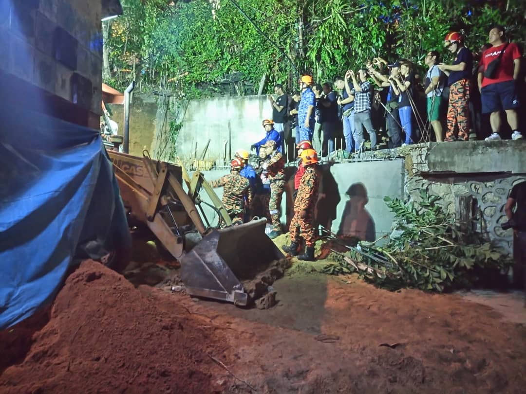 Fire and Rescue Department personnel search for victims of a landslide in Tanjung Bungah, George Town June 25, 2019. u00e2u20acu201d Picture courtesy of the Penang police