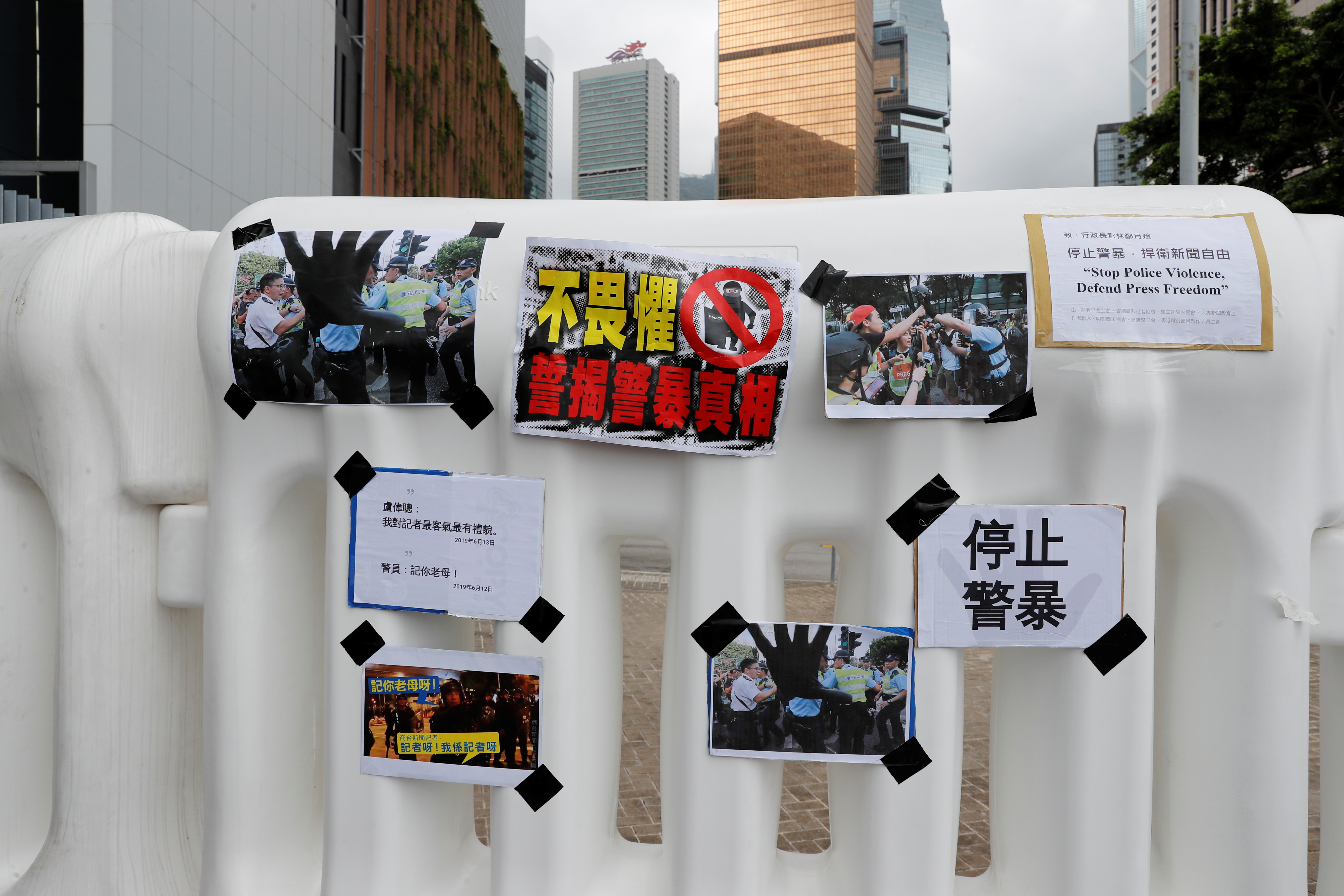 7个工会的代表们也将记者遭粗暴对待的相片及声明书，贴在特首办外围围栏上。-路透社-