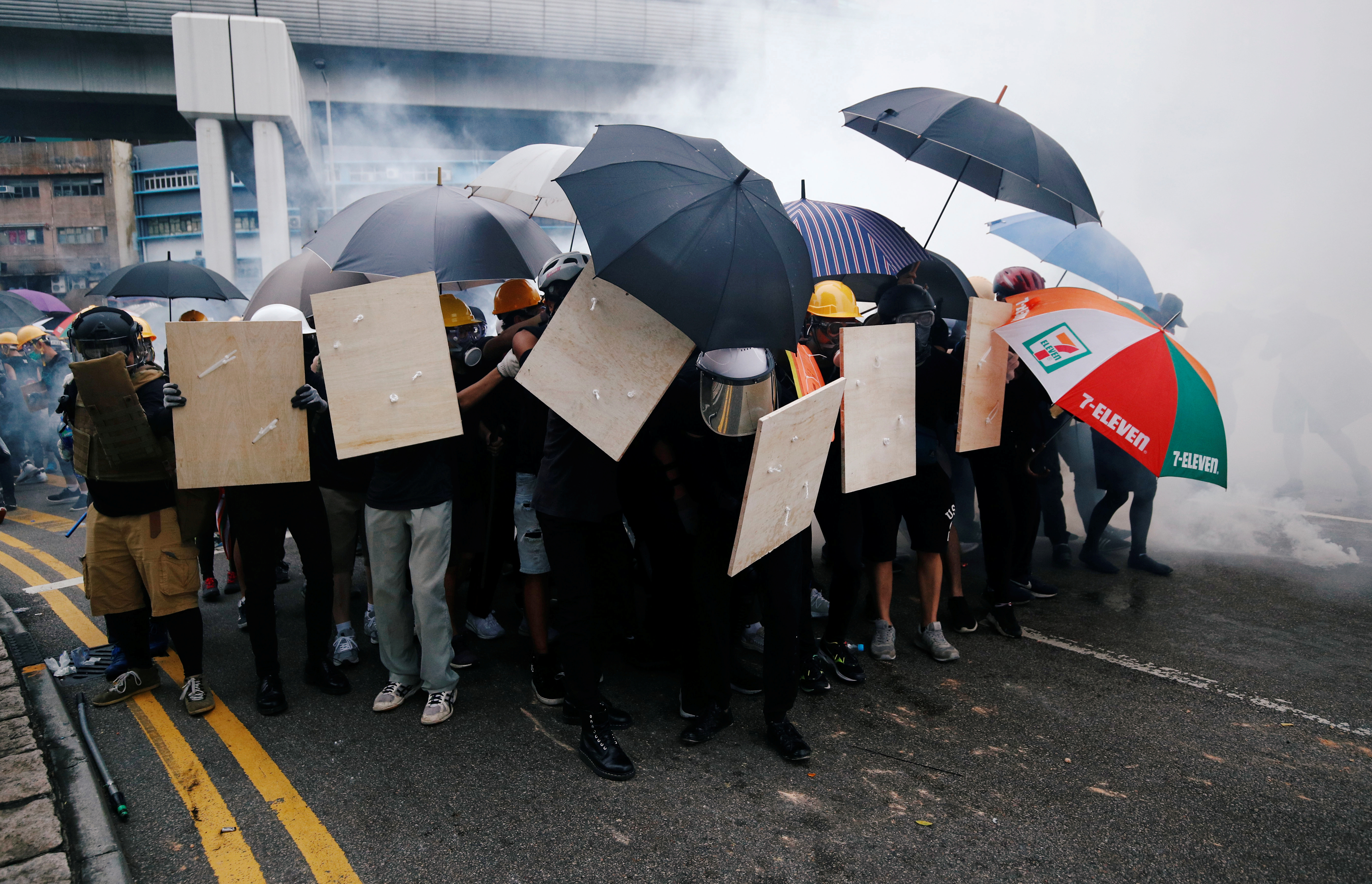 南边围村的示威者打开雨伞等防御工具，部分人情绪激动，不断高叫“警察包庇黑社会。”-路透社-