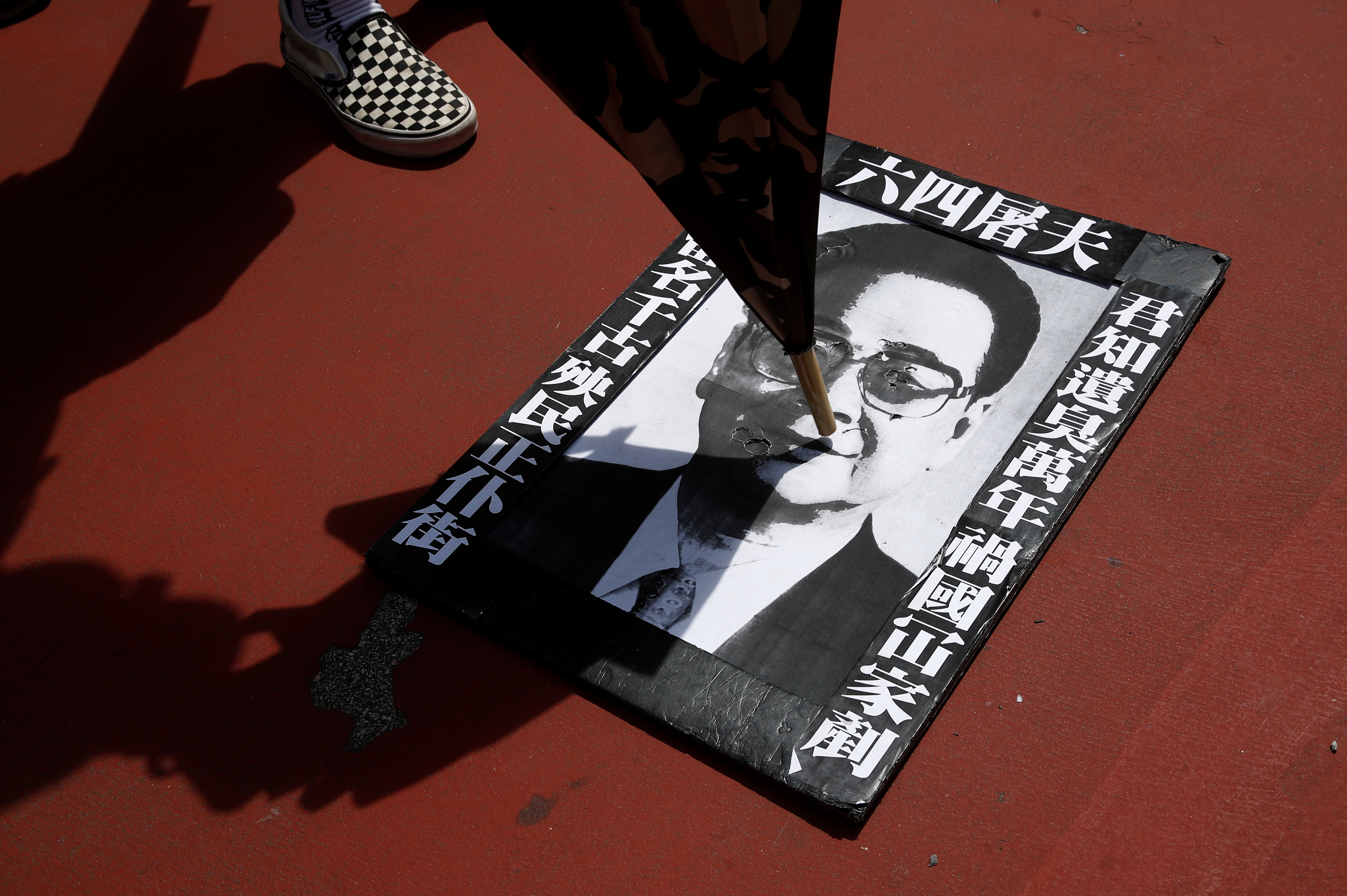 有市民将李鹏肖像海报放置在地上，让途经市民会任意上前践踏。-路透社-