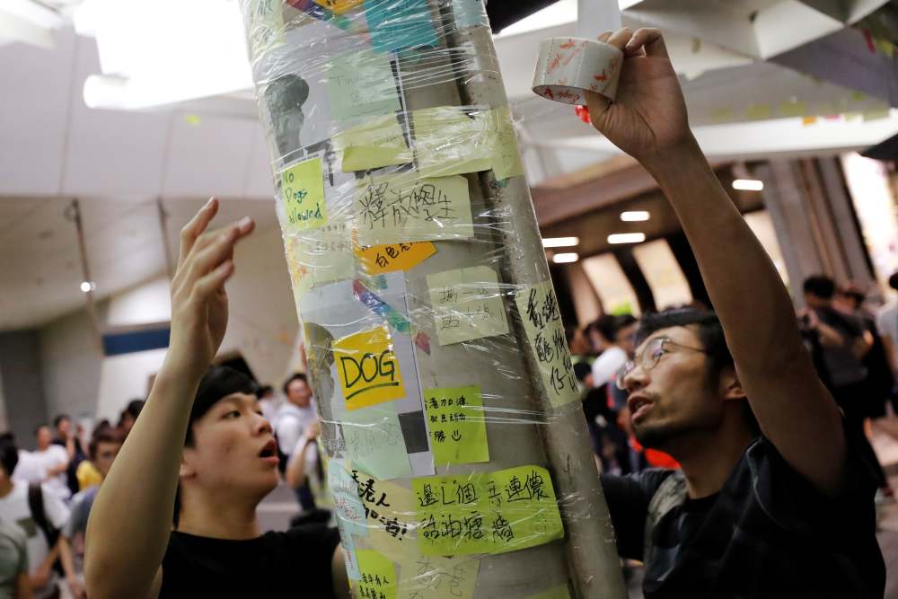 Anti-extradition Bill protesters wrap plastic tape to protect the memos on u00e2u20acu02dcLennon Wallsu00e2u20acu2122 at Yau Tong in Hong Kong July 11, 2019. u00e2u20acu2022 Reuters pic