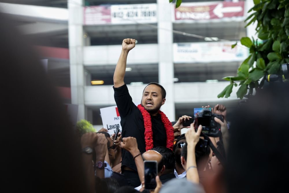 Farhash Wafa Salvador Rizal Mubarak gestures to the crowd as he leaves the Dang Wangi police station in Kuala Lumpur July 23, 2019. u00e2u20acu2022 Picture by Ahmad Zamzahuri