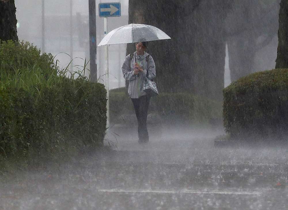 A pedestrian walks through heavy rain in Kirishima, Kagoshima Prefecture, southwestern Japan July 3, 2019. u00e2u20acu201d Kyodo pic via Reuters