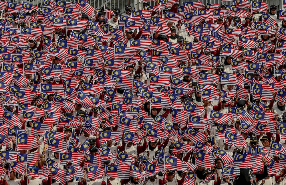 Participants wave the Malaysian flag during a National Day rehearsal in Putrajaya August 29, 2019. u00e2u20acu201d Picture by Firdaus Latif