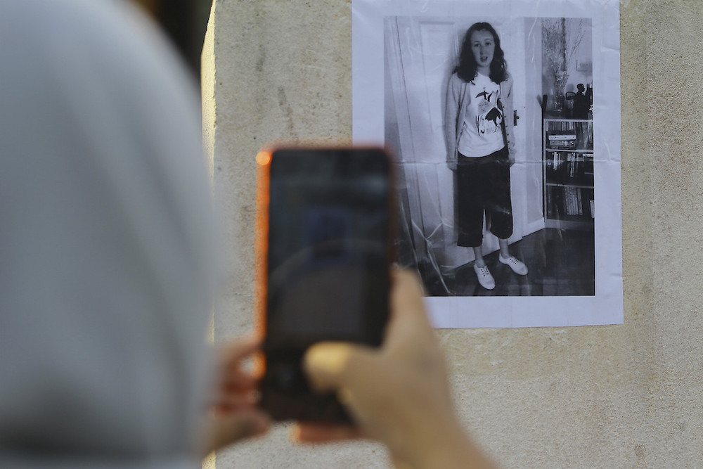 A woman takes a picture of a poster featuring missing Irish teenager Nora Anne Quoirin in Seremban August 5, 2019. u00e2u20acu201d Bernama pic