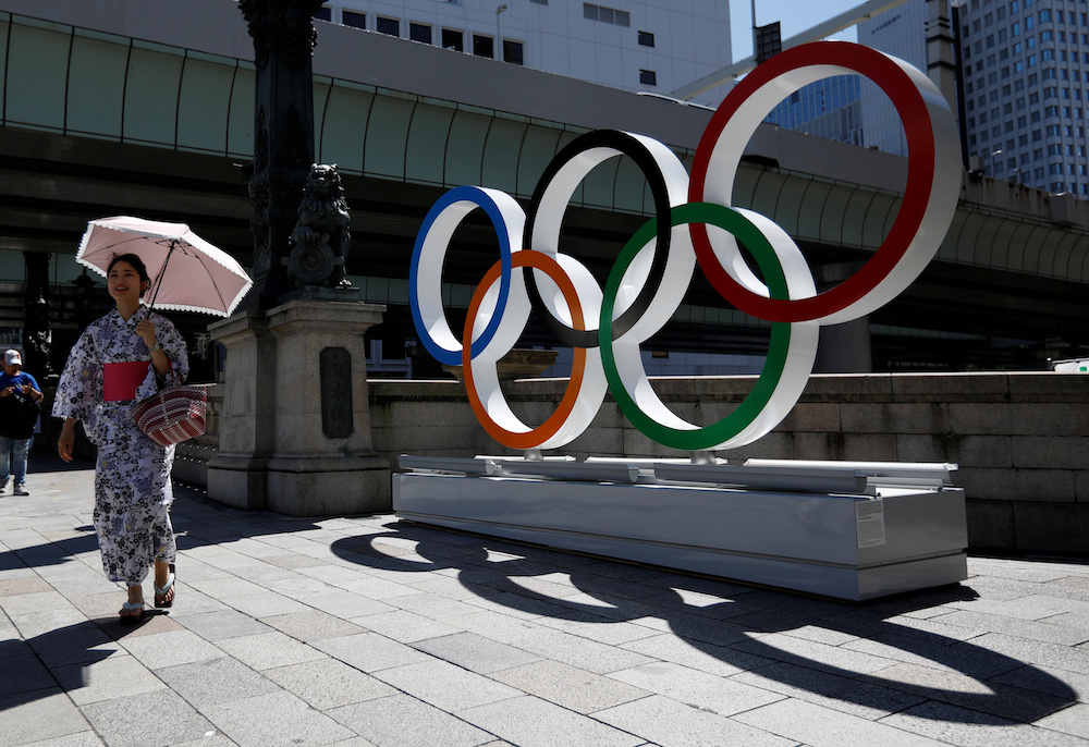 A woman wearing the yukata, or casual summer kimono, walks past Olympic rings displayed at Nihonbashi district in Tokyo, Japan August 5, 2019. Picture taken August 5, 2019. u00e2u20acu201d Reuters picn n