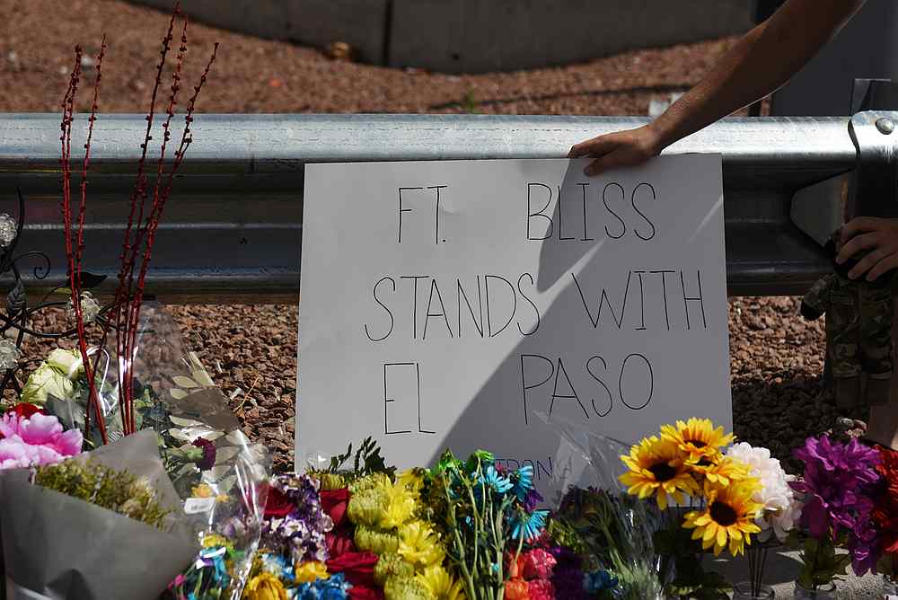 A man places a sign behind the pile of flowers that has gathered a day after a mass shooting at a Walmart store in El Paso, Texas August 4, 2019. u00e2u20acu201d Reuters pic