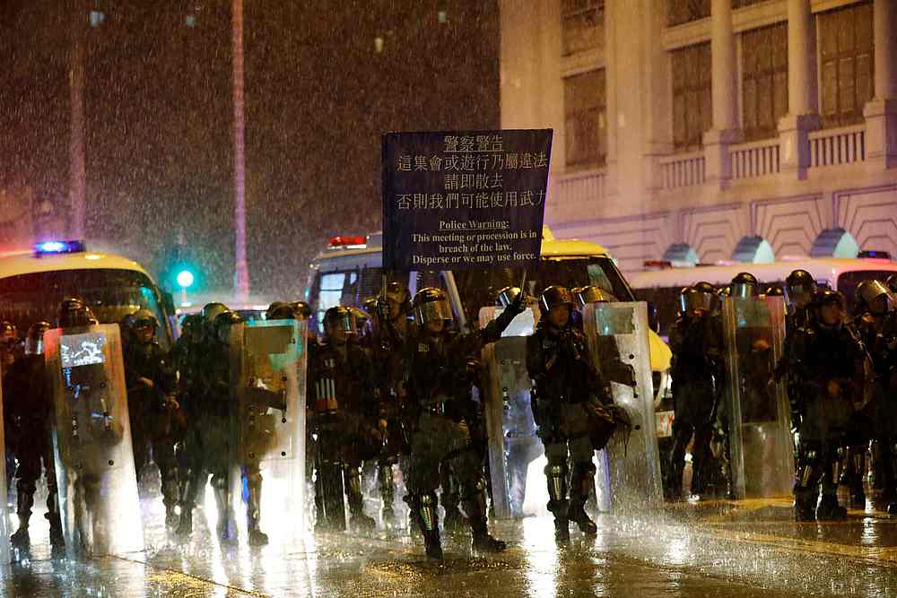 Riot police officers raise a warning flag as they stand guard during a protest in Hong Kong August 25, 2019. u00e2u20acu201d Reuters pic