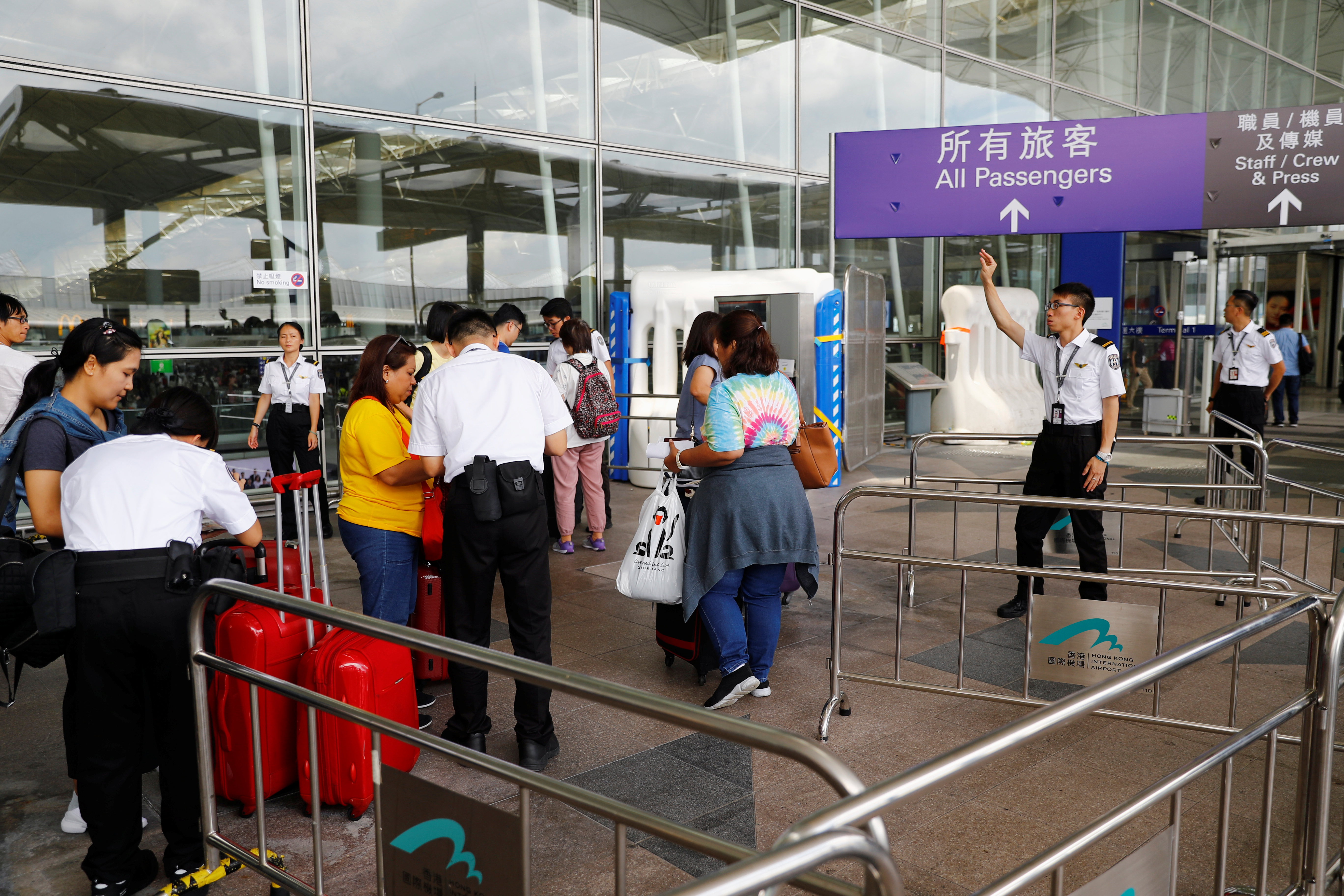 “反送中”网民发起周日下午堵塞机场，机场管理局早上在机场离境层出入口放置了大型水马及铁栅栏。-路透社-