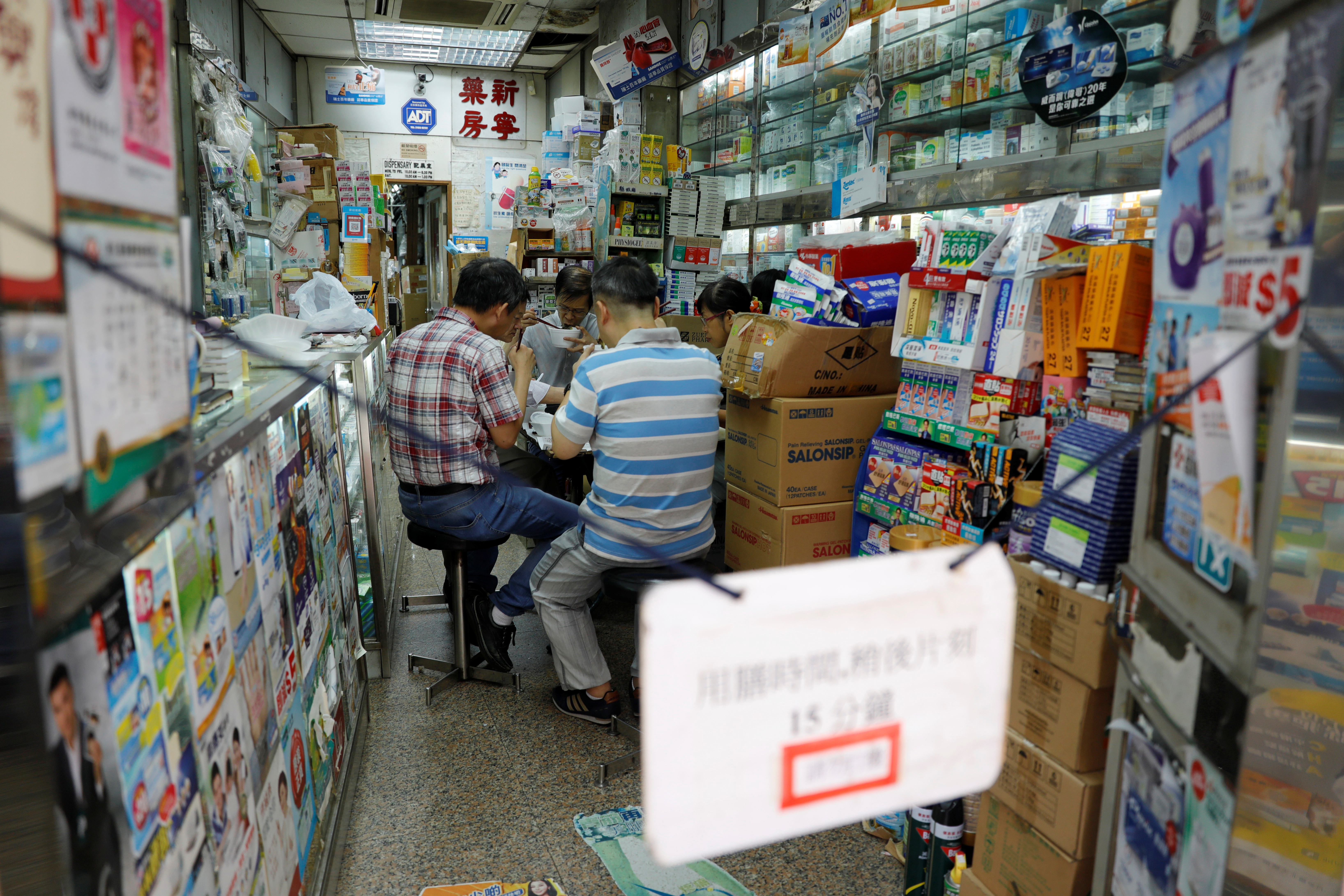 香港湾仔附近的药店，员工们正在店内享用午餐。-路透社-