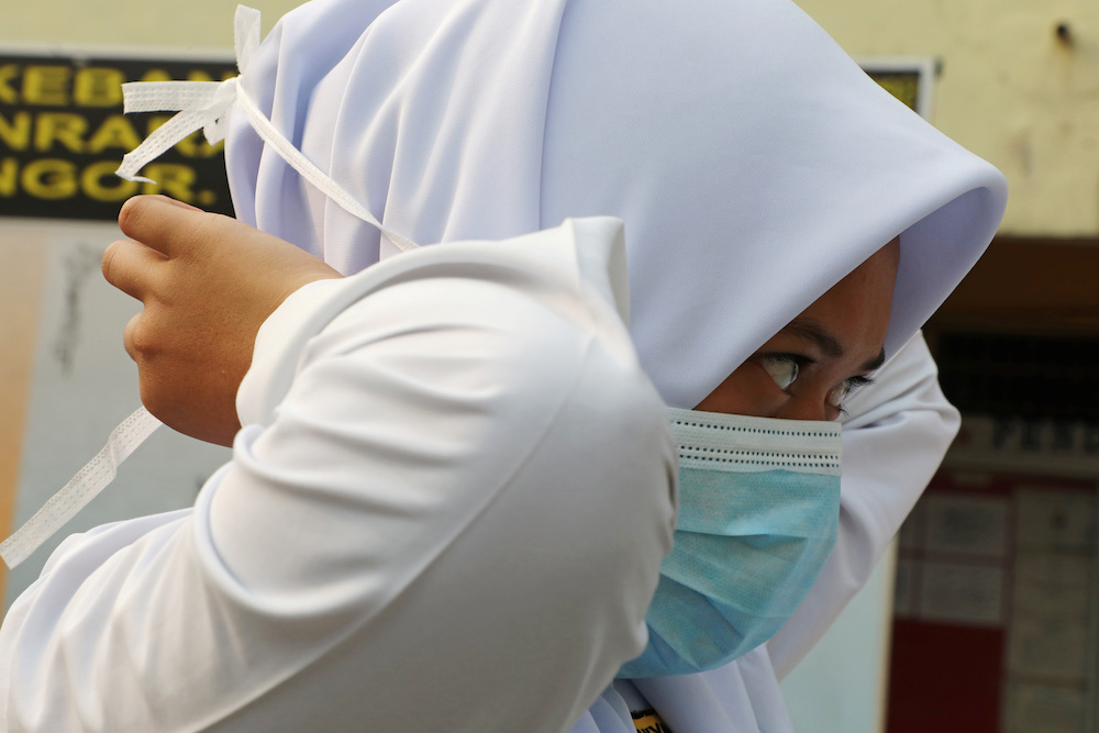 A student covers her face with a mask at a school in Puchong as haze shrouds Kuala Lumpur September 12, 2019. u00e2u20acu201d Reuters pic