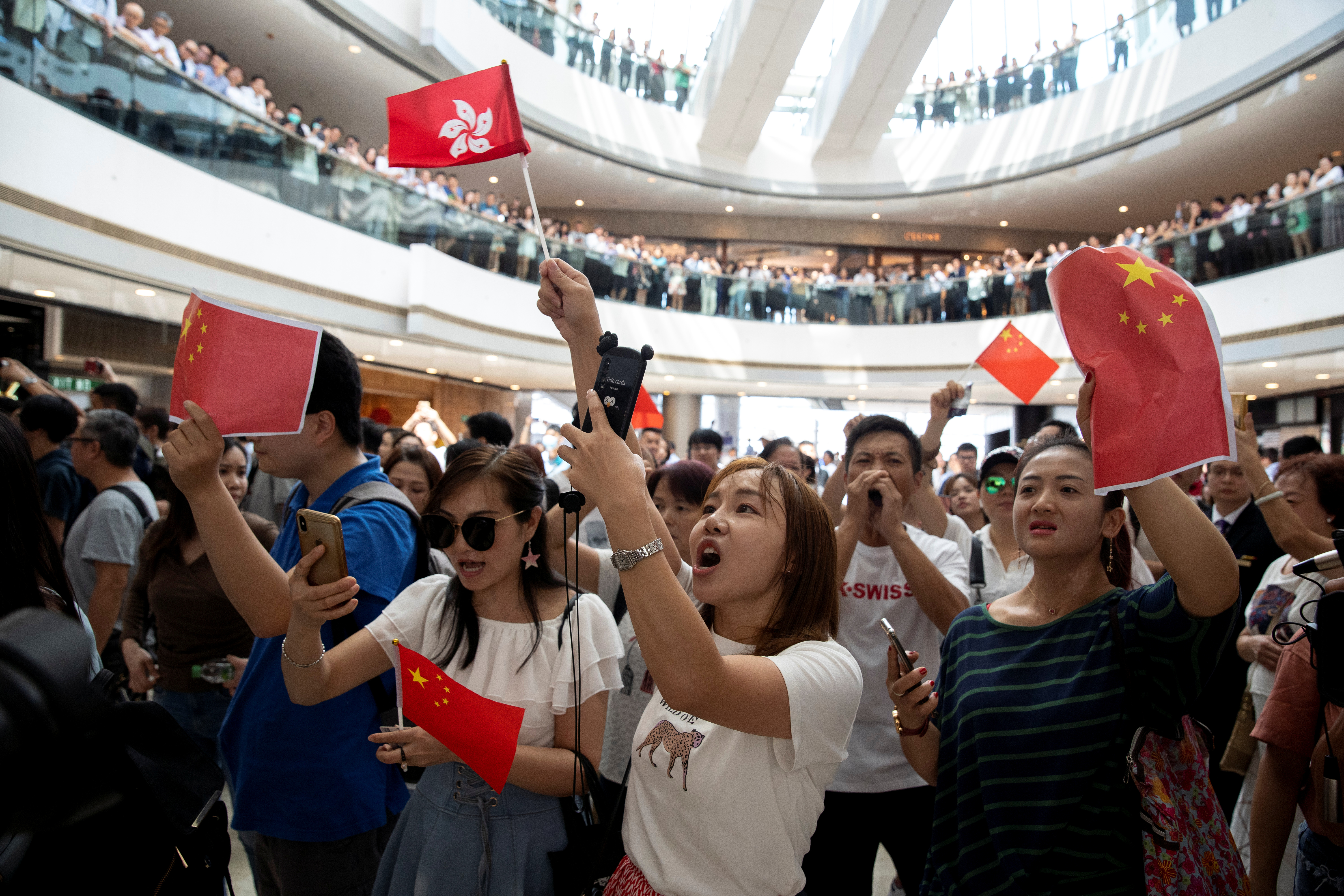 有持中国国旗的人在香港中环的商场聚集，同时合唱中国国歌，表达对示威者的不满。-路透社-