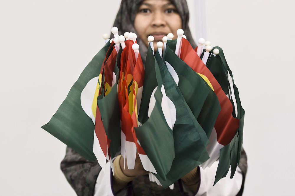 A woman holds PAS-Umno flags during Himpunan Penyatuan Ummah (Muslim Unity Rally) at Putra World Trade Centre in Kuala Lumpur September 13, 2019. u00e2u20acu201d Picture by Miera Zulyana