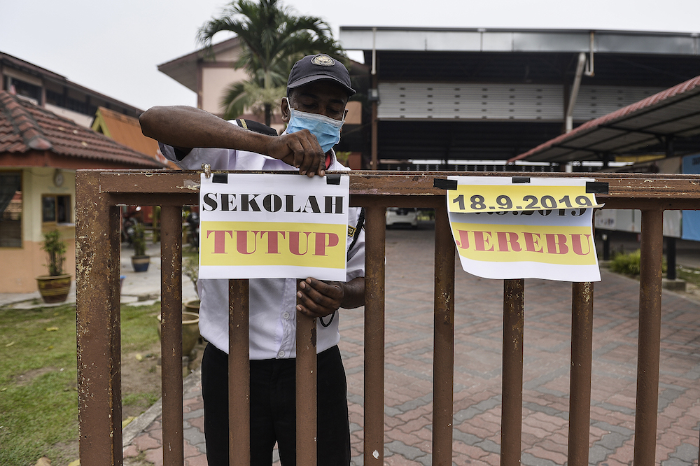 A security guard closes the gate of Sekolah Kebangsaan Kampung Johan Setia in Klang September 18, 2019. u00e2u20acu201d Picture by Miera Zulyana