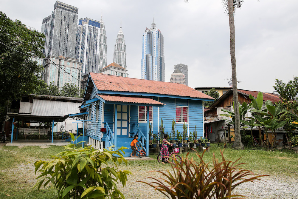 Children playing outside their house in Kampung Baru with the iconic Twin Towers looming behind them. u00e2u20acu201d Picture by Yusof Mat Isa