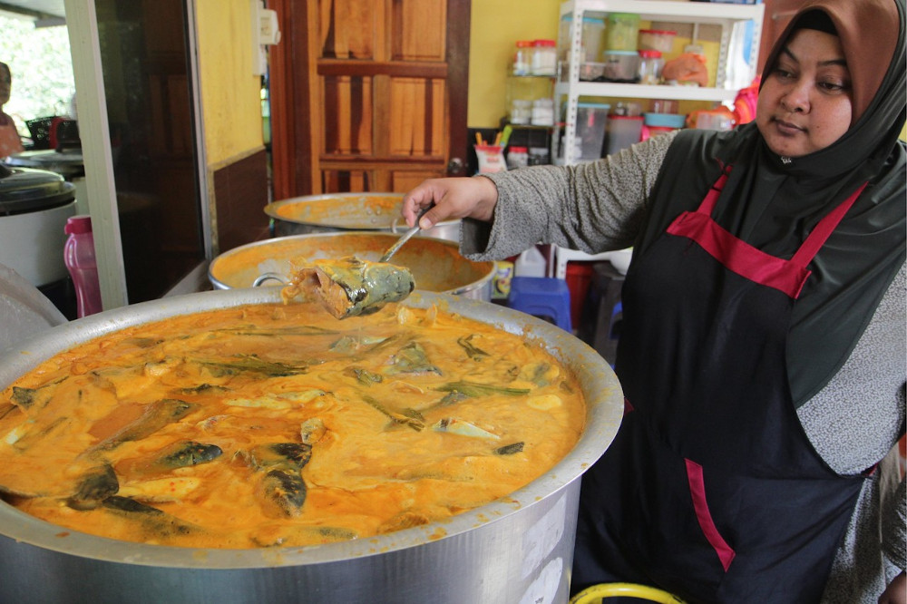 Restaurant owner Rohazlina Yusof, 43, with a pot of ikan patin gulai tempoyak at her restaurant in Kampung Bangau Tanjung, Temerloh September 21, 2019. u00e2u20acu201d Bernama pic