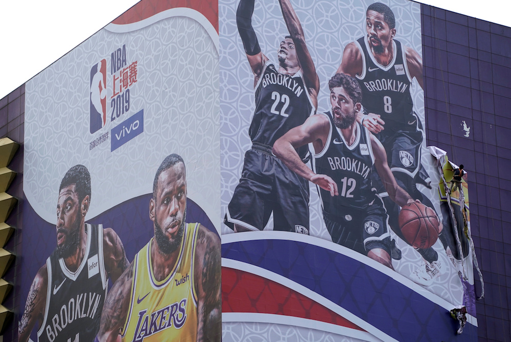 A worker removes a giant advertisement of the NBA China Games from a building in Shanghai October 9, 2019. u00e2u20acu201d Reuters pic