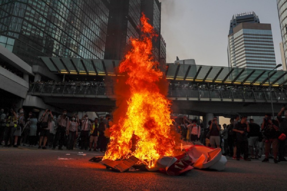 示威者聚集在香港中环抗议《禁蒙面法》，并焚烧中国70周年国庆布条。-法新社-