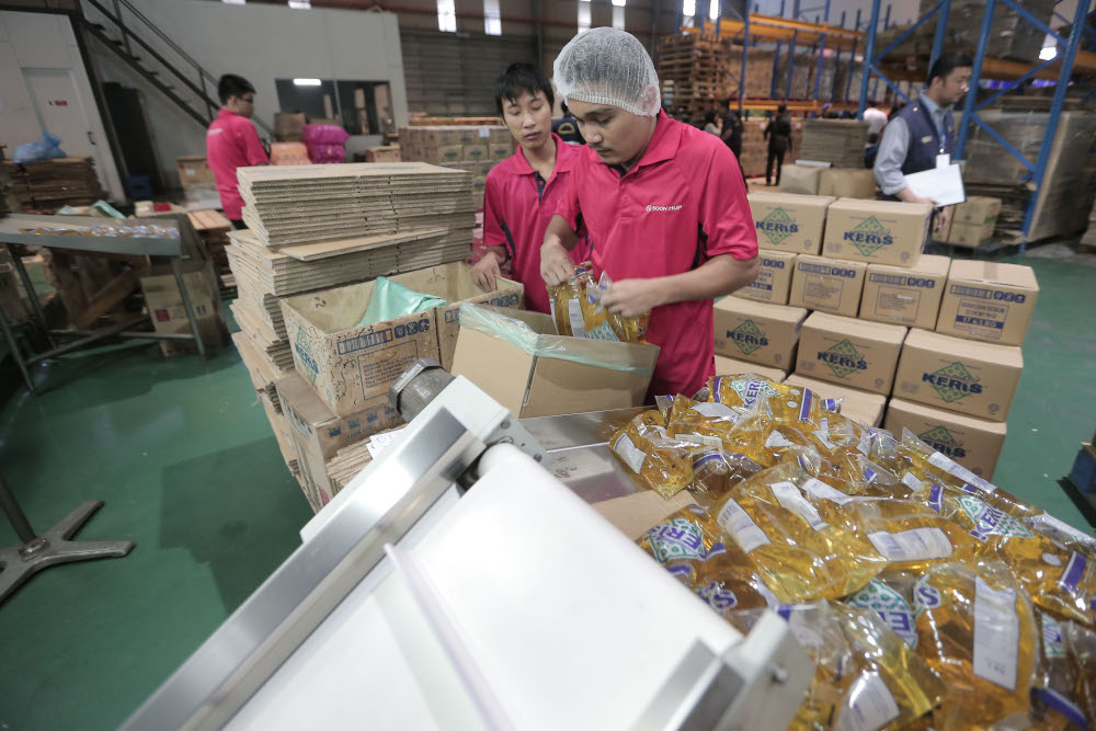 Workers from Soon Hup Oil factory are busy packaging the subsidised cooking oil November 9, 2016. u00e2u20acu201d Picture by Azinuddin Ghazali