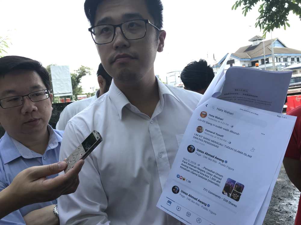 DAP Socialist Youth (Dapsy) National chief Howard Lee shows the police report filed against a Facebook user for posting death threat on Lim Kit Siang. u00e2u20acu2022 Picture by John Bunyan