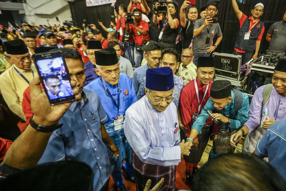 Prime Minister Tun Dr Mahathir Mohamad arrives for the Malay Dignity Congress in Shah Alam October 6, 2019. Datuk Abdul Rahim Hashim is behind him, in blue baju Melayu and songkok. u00e2u20acu201d Picture by Hari Anggara