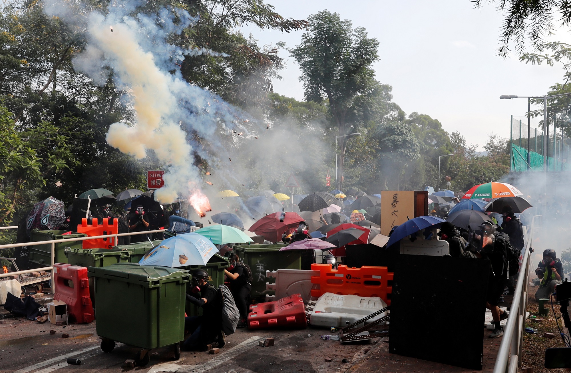 University students take cover as they standoff with riot police at the Chinese University of Hong Kong, Hong Kong, China November 12, 2019. REUTERS/Tyrone Siu