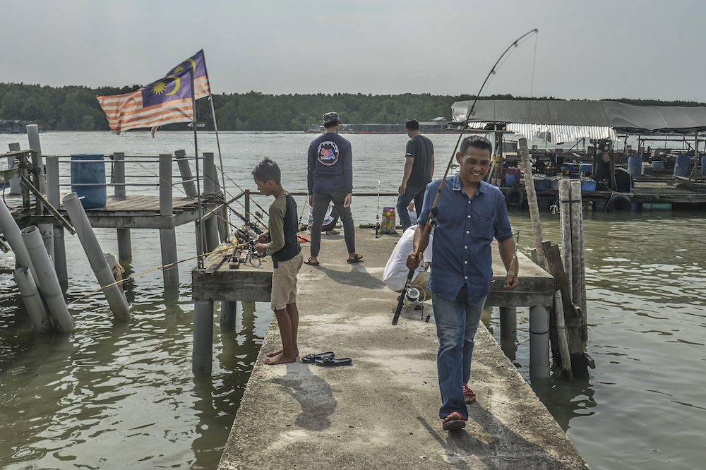 People fish in Kampung Air Masin in Kukup November 3, 2019. u00e2u20acu201d Picture by Shafwan Zaidon 