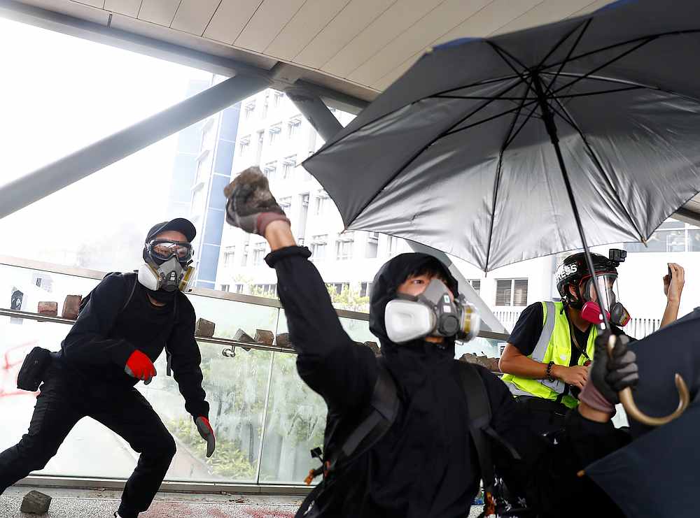 A demonstrator throws a rock on a footbridge during an anti-government protest near City University in Kowloon Tong, Hong Kong November 12, 2019. u00e2u20acu201d Reuters pic 