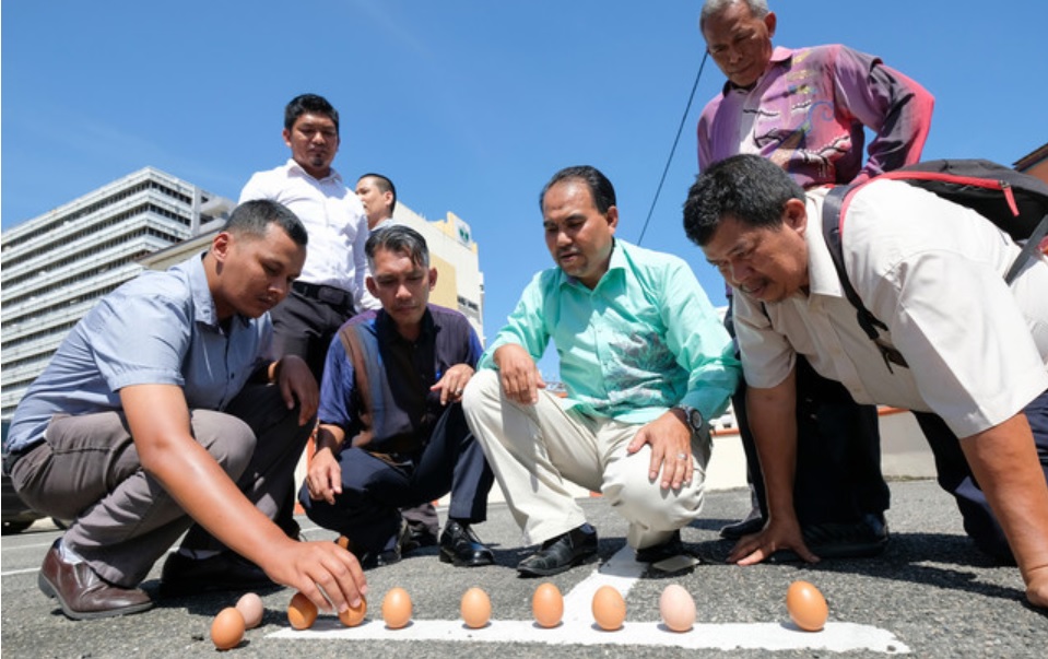 除了很多人忙着望天上，也有很多民众忙着让蛋在地上“排排站”。-马新社-