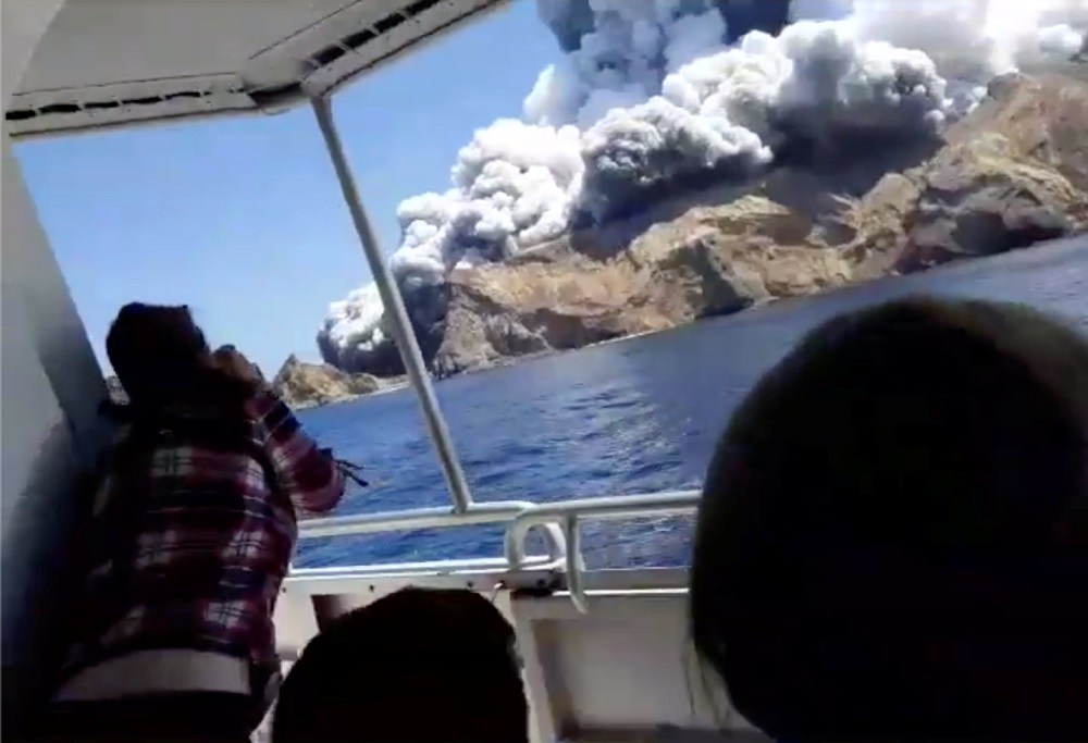 People on a boat react as smoke billows from the volcanic eruption of Whakaari, also known as White Island, New Zealand December 9, 2019. u00e2u20acu201d Picture via Instagram/allessandrokauffmann/via Reuters