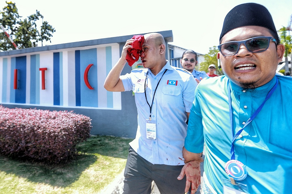 An injured PKR member is led away following a brawl that took place outside the Melaka International Trade Centre complex in Melaka December 6, 2019. u00e2u20acu201d Picture by Ahmad Zamzahurin