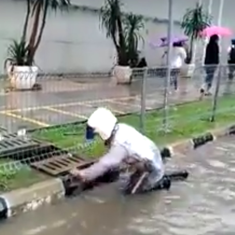 The dutiful officer took it upon himself to clear the drains and get traffic moving. u00e2u20acu201d Screengrab from Facebook/PolisDirajaMalaysiann