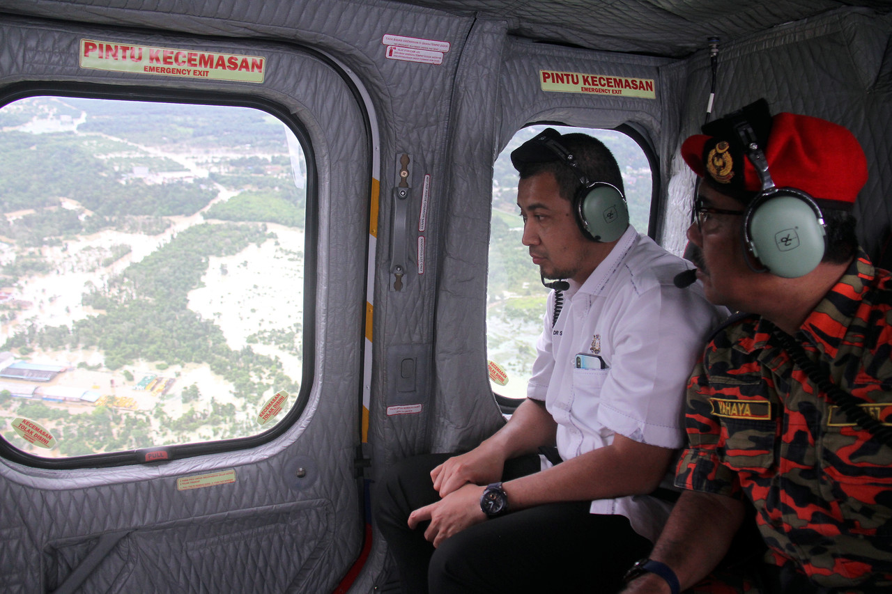 Johor Chief Minister Datuk Dr Sahruddin Jamal (left) and Johor Fire Director Datuk Yahaya Madis surveying the flood situation around Kota Tinggi onboard a Fire and Rescue Department helicopter December 16, 2019. u00e2u20acu201d Bernama pic