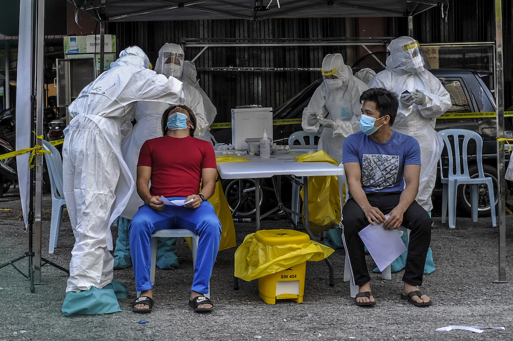 Health workers testing members of the public for Covid-19 at Flat PKNS Kampung Baharu in Kuala Lumpur April 12, 2020. u00e2u20acu201d Picture by Shafwan Zaidon