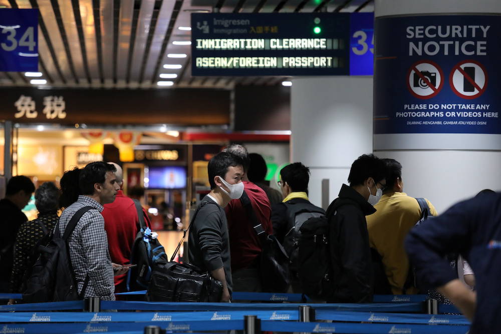 Passengers wearing masks wait in line at Kuala Lumpur International Airport in Sepang January 21, 2020. u00e2u20acu201d Reuters pic