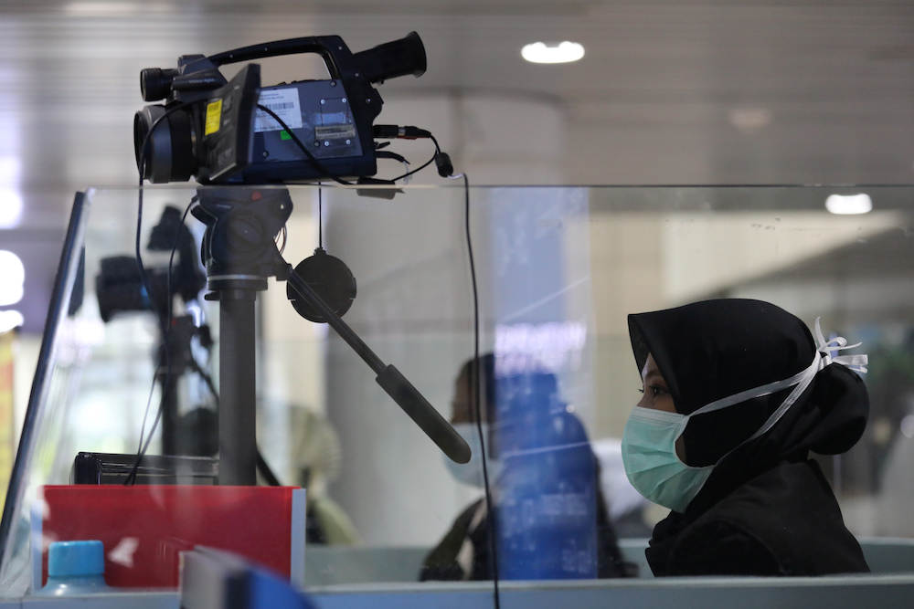 A Malaysian health quarantine officer waits for passengers at a thermal screening point at the international arrival terminal of Kuala Lumpur International Airport in Sepang January 21, 2020. u00e2u20acu201d Reuters pic