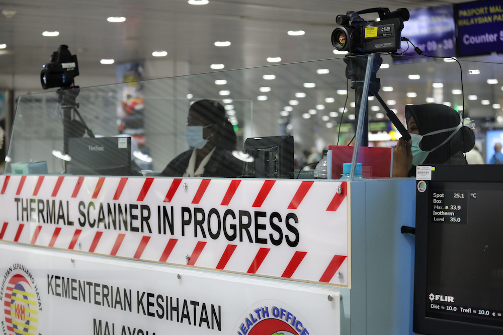 A Malaysian health quarantine officer waits for passengers at a thermal screening point at the international arrival terminal of Kuala Lumpur International Airport in Sepang January 21, 2020. u00e2u20acu201d Reuters pic