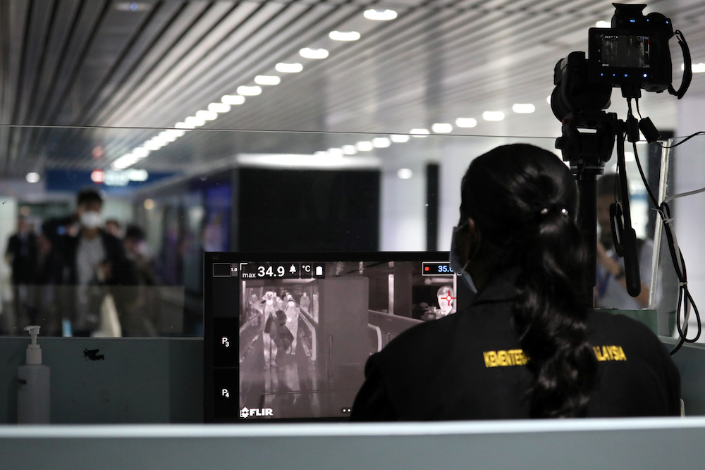 A Malaysian health quarantine officer waits for passengers at a thermal screening point at the international arrival terminal of Kuala Lumpur International Airport in Sepang January 21, 2020. u00e2u20acu201d Reuters pic