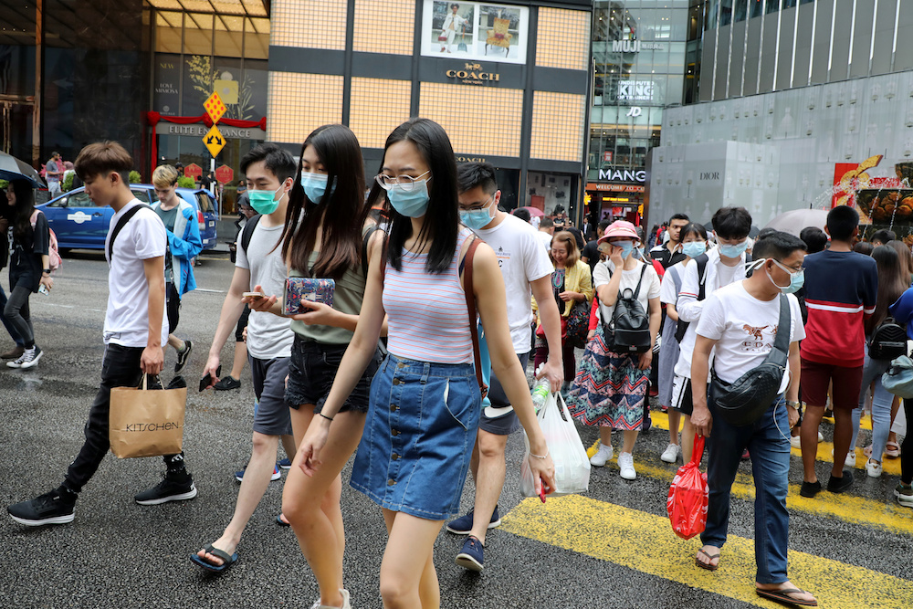 Tourists wearing masks cross a street outside a shopping mall in Kuala Lumpur January 29, 2020. u00e2u20acu201d Reuters pic